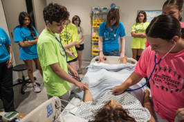 High school students practice on a mannequin at the UNH Health Sciences Simulation Center