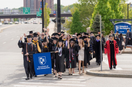 UNH Manchester graduates process up a Queen City street