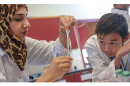 UNH Manchester biololgy teaching assistant Zaynav Mahmod from Jordan assists Tan Dao from Vietnam precipitate his DNA sample during UNH Manchester's Summer EXCELL Program.