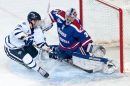 men's ice hockey player at goal against competing team