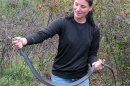 student with black racer snake