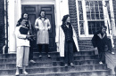 Female students outside academic building in blue jeans (dungarees)