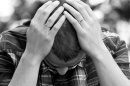 man looking down with his head in his hands