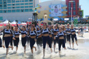 UNH cheerleaders running into the ocean with a trophy