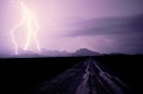 lightning against a purple sky and mountainous landscape (Bruce Dale/National Geographic Creative)