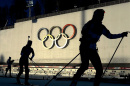 skiers in front of the olympic rings