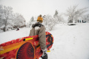 UNH student carrying sled during snowstorm