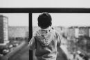 Image of child looking out a window