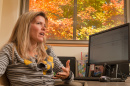 Corinna Tucker sits at a computer in front of a window