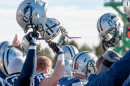 football helmets being held in the air by players