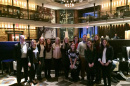Hospitality management students and alumni pose at a hotel