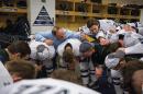 Coach Dick Umile and UNH hockey players in the locker room before a game