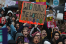 Protesters hold up placards during the Women's March in London on Jan. 21, 2018