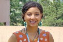 Tamara Marcus smiles at the camera wearing an orange printed top