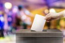 voter putting ballot in box