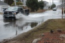 Two vehicles drive through flooded road conditions.