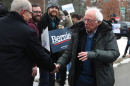 Bernie Sanders shakes hands with supports outside. 