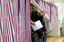 A women exits a voting booth 