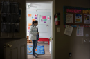 A women waits for a staff member to retrieve her child's belongings