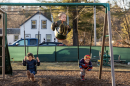 Children swing on swings outside of their early learning center in New Hampshire 