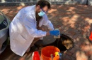 KELLEN SAWYER, A RESEARCH TECHNICIAN LEADING THE UNH SEWAGE MONITORING, RETRIEVES A SAMPLE FROM ONE OF THE MANHOLES 