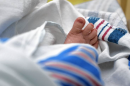 A newborn lays in the hospital wrapped in a blanket.