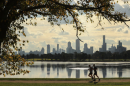 Two people jog in front of the New York City skyline