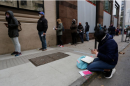 Men and women wait in line at an unemployment center 