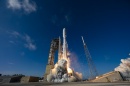 Rocket launches with smoke and flames behind it.