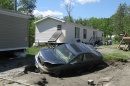 car in sinkhole by mobile home