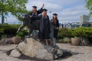 Students surround Wildcat statue during commencement
