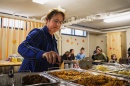 Woman stirs food in a heated tray
