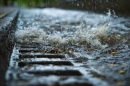 Close-up of stormwater drain with water gushing into it