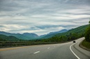 car driving on empty highway with mountains in backgroun