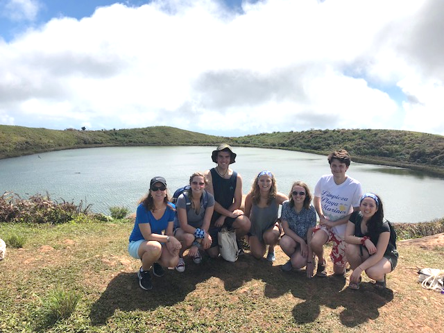 students and leader in front of water at volcano