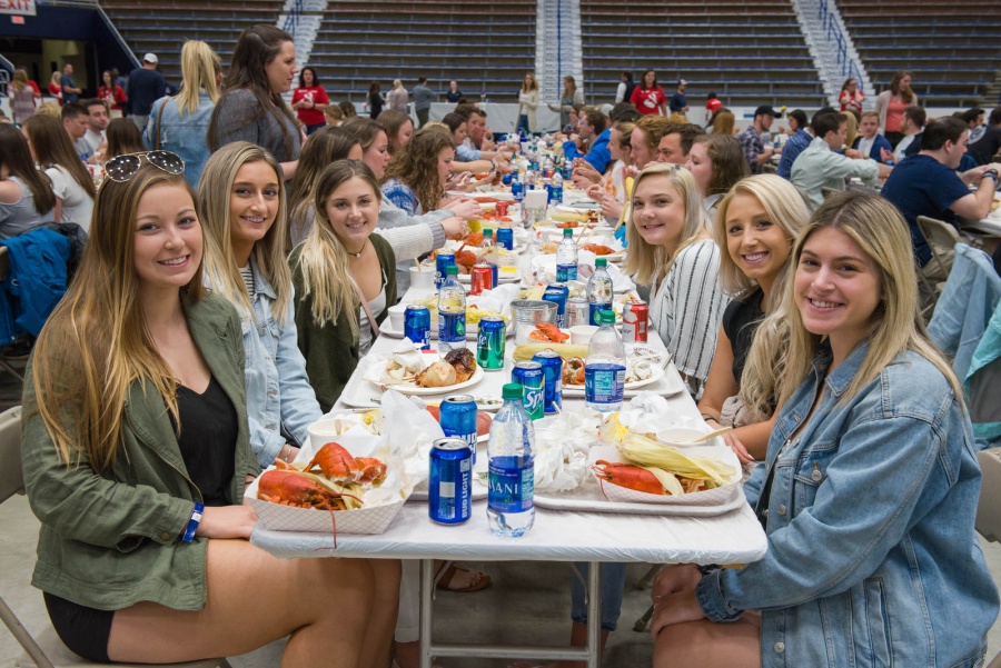 UNH seniors celebrating their impending graduation with classmates over lobster in the rough 