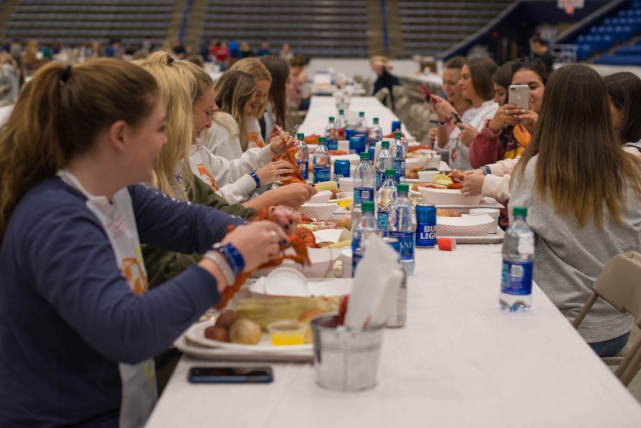 UNH seniors celebrating their impending graduation with classmates over lobster in the rough 