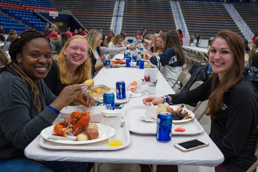 UNH seniors celebrating their impending graduation with classmates over lobster in the rough 