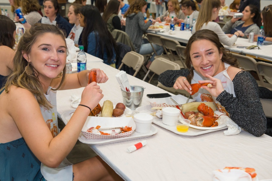 UNH seniors celebrating their impending graduation with classmates over lobster in the rough 