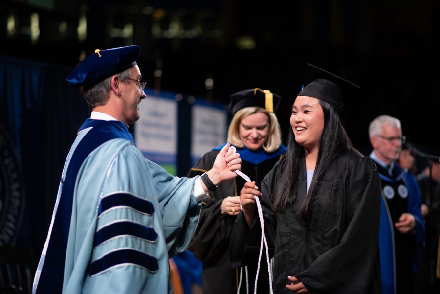A UNH student receives their cord
