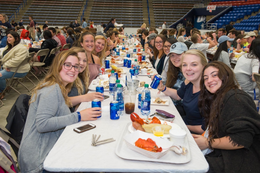 UNH seniors celebrating their impending graduation with classmates over lobster in the rough 