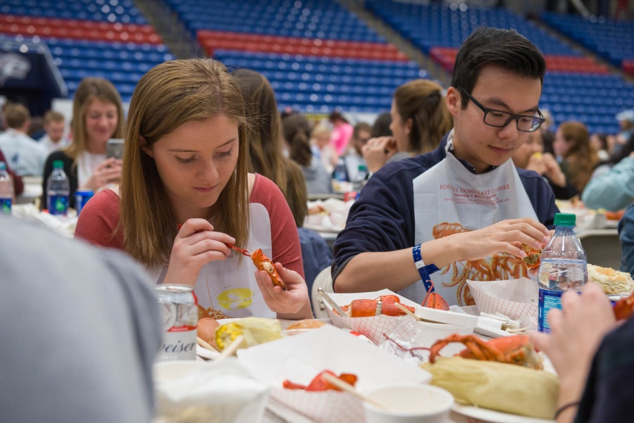 UNH seniors celebrating their impending graduation with classmates over lobster in the rough 