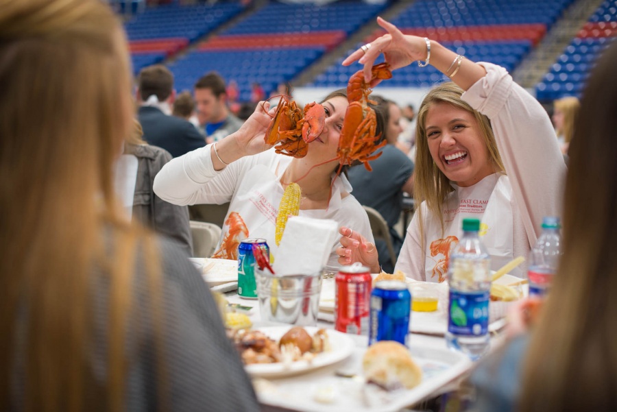 UNH seniors celebrating their impending graduation with classmates over lobster in the rough 