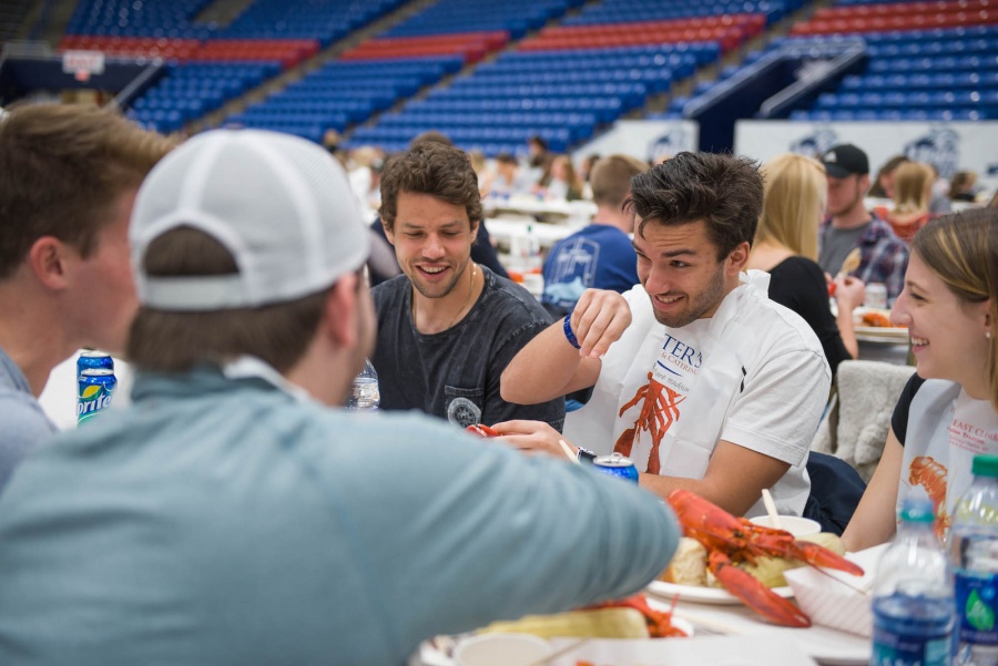 UNH seniors celebrating their impending graduation with classmates over lobster in the rough 