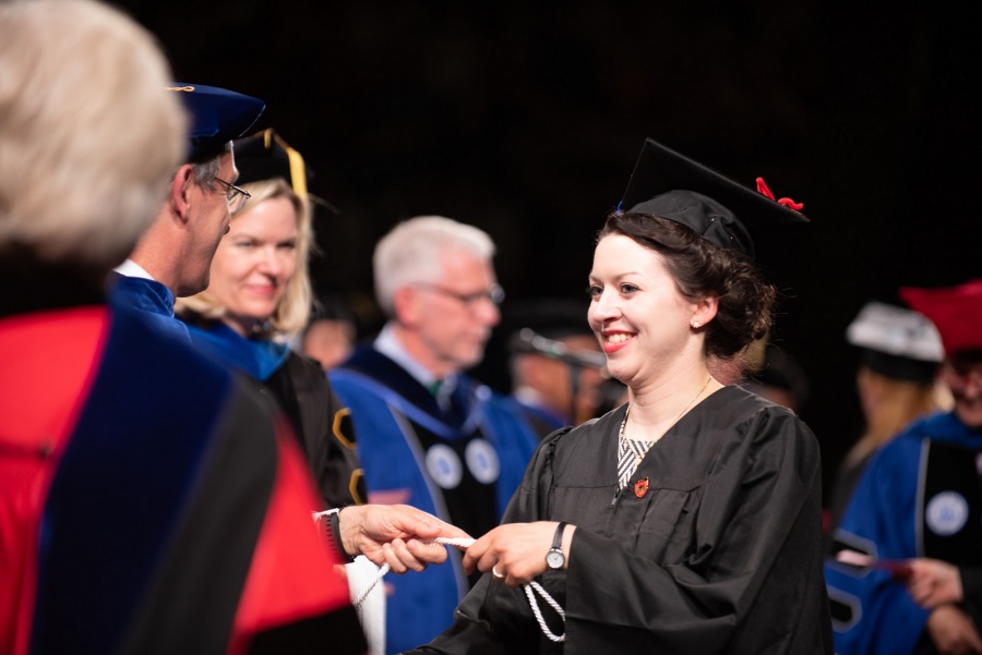 A UNH student receives their cord