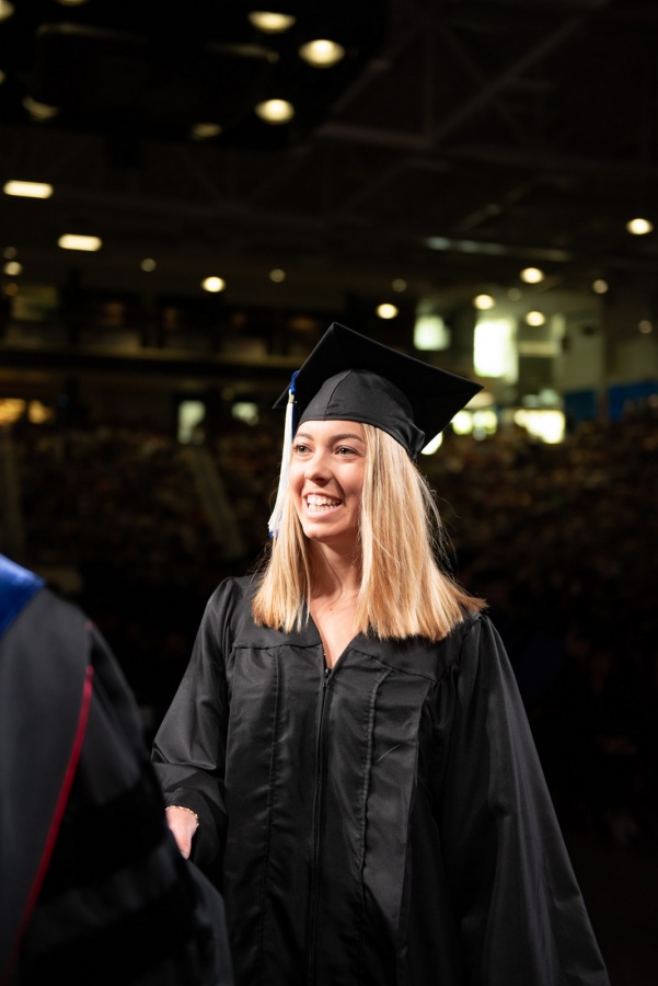 A UNH student receives their cord