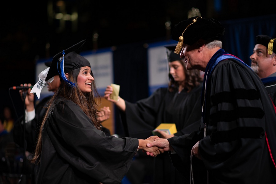 A UNH student receives their cord