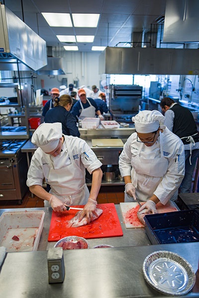 Brad LaMonica and Ciara McCarter from UNH’s Thompson School of Applied Science Culinary Arts & Nutrition program filet and bag tilapia