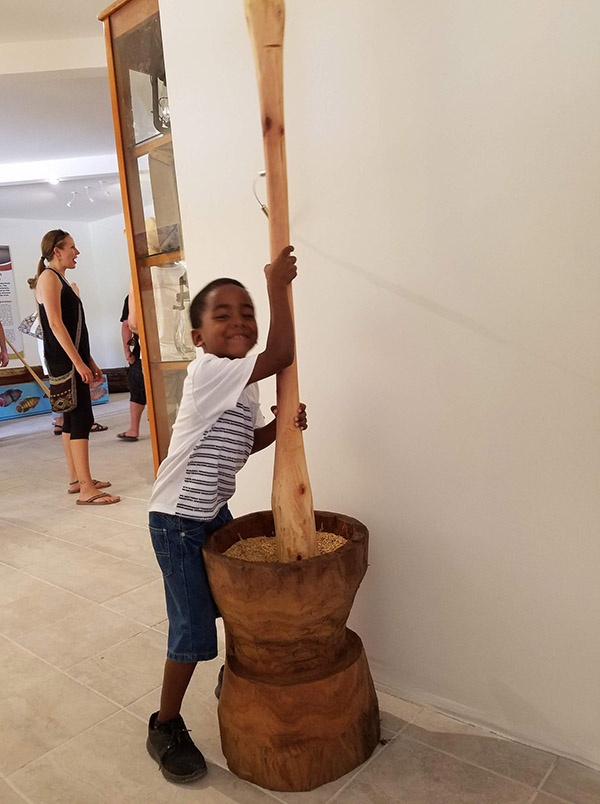 a boy playing with rice pounder