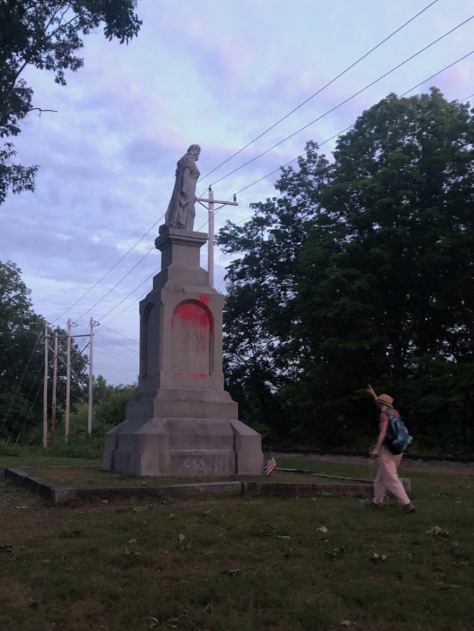 statue with person pointing up at it